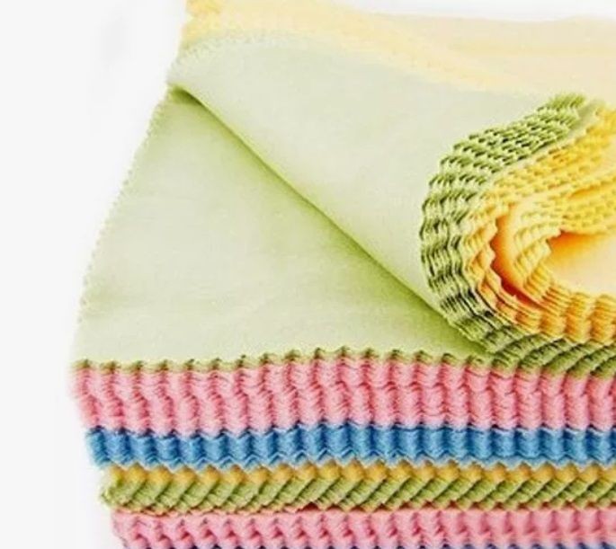 A stack of multicolored microfiber cleaning cloths in pastel shades, neatly folded and arranged.